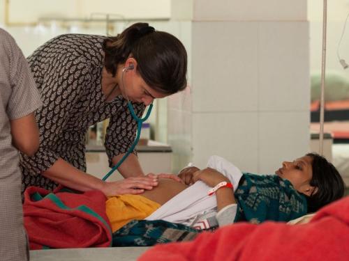 Doctor examining a young girl in a hospital bed