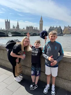 A mum and her two sons standing together with Big Ben visible behind them.