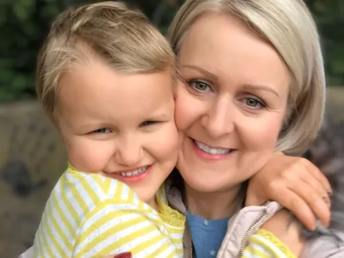 Claire and Ruby hugging and smiling at the camera with short blonde hair.