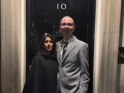 Ashley Ball-Gamble and Dr Shaarna Shanmugavadivel standing in front of the black door for Number 10 Downing Street